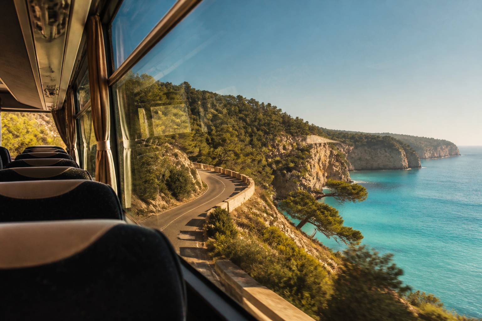Route cĂŽtiĂšre vue depuis un bus vers une mer turquoise